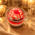 Strawberry chocolate donut sandwich candle in a glass mug on a warm golden background