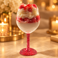 Strawberry shortcake candle in a red rhinestone-stem glass on a warm golden background